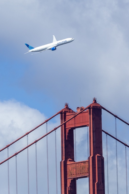 United Airlines widebody jet passing over the north tower of the Golden Gate Bridge